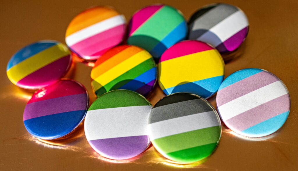 Colorful queer-themed buttons featuring various LGBTQ+ pride flags, symbolizing diversity and inclusion in queer therapy support in Halifax.