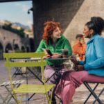 Two people chatting warmly at an outdoor café, symbolizing the connection and conversation at the heart of narrative therapy in Halifax and across Nova Scotia.
